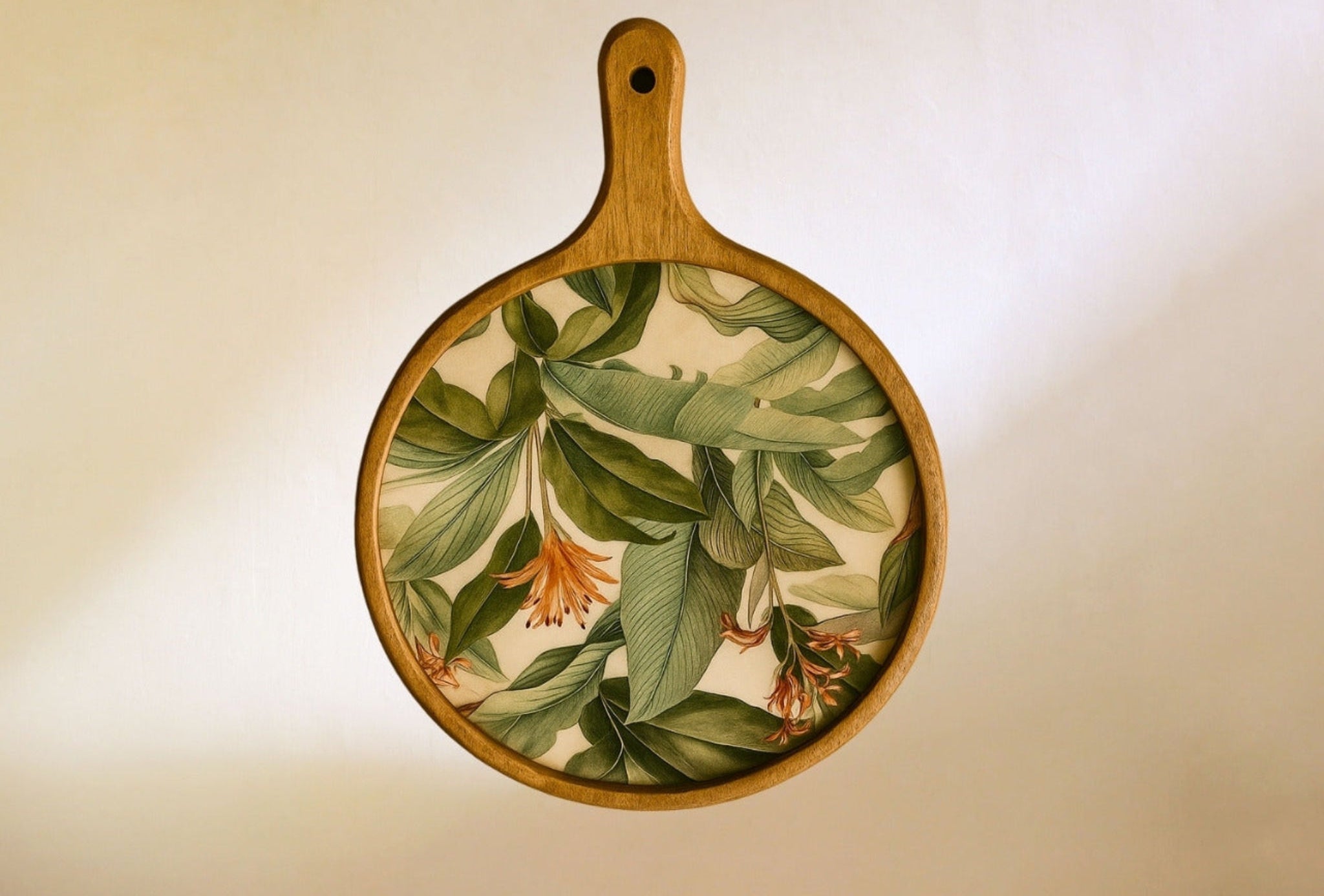 Wooden paddle with floral and leaf design on a beige background